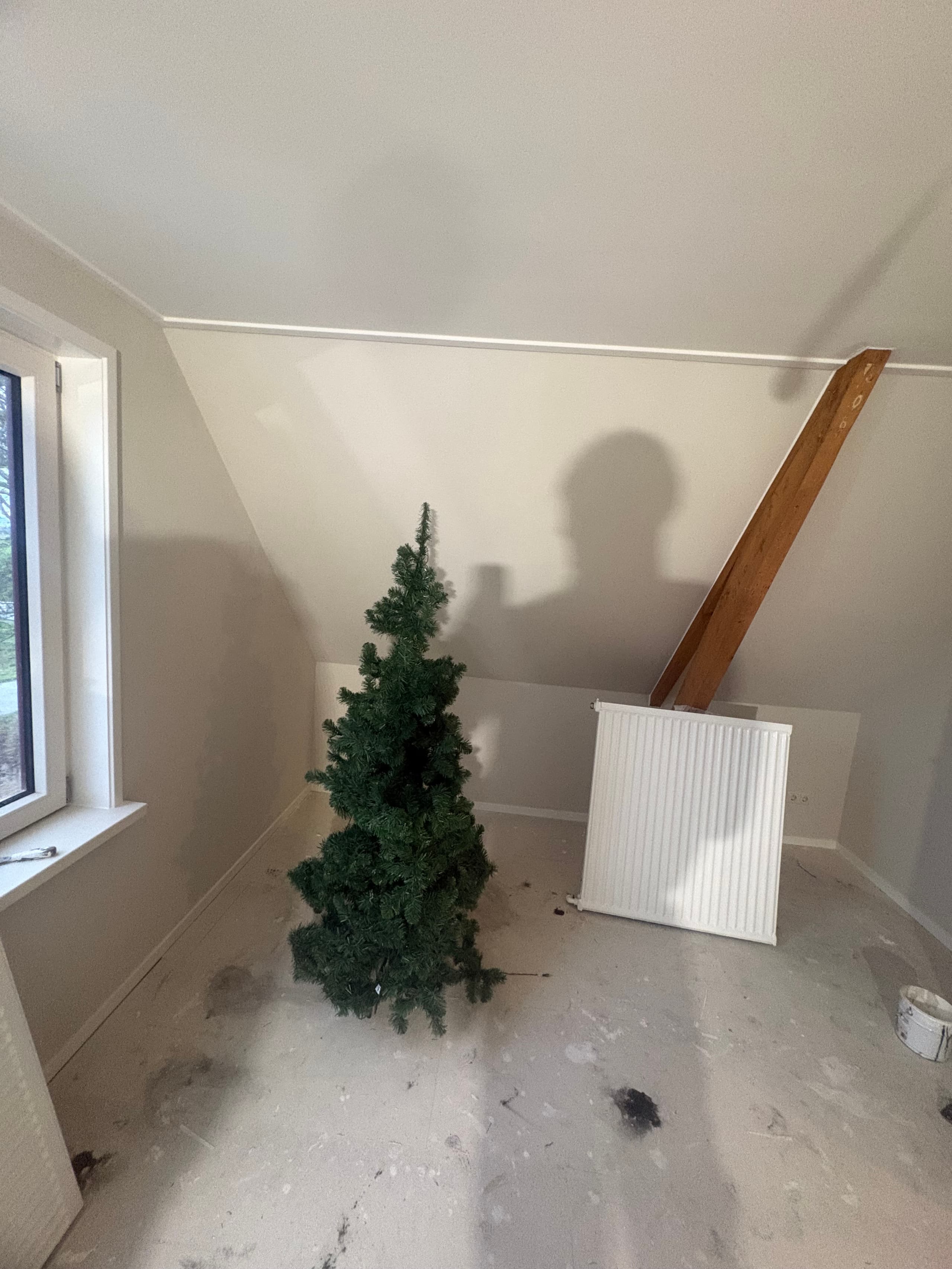 Zolderkamer in Wanswert met nieuw afgewerkte lichte wanden, een schuin plafond en een houten spant, tijdens de afwerking